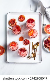 Homemade Italian Granita Dessert With Blood Orange, Elderflower, Rose Wine  In Serving Glasses On A White Metal Tray On A White Table. Flat Lay, Top View.