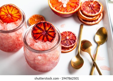 Homemade Italian Granita Dessert With Blood Orange, Elderflower, Rose Wine  In Serving Glasses On A White Metal Tray On A White Table.