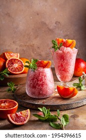 Homemade Italian Granita Dessert With Blood Orange, Elderflower, Rose Wine  In Serving Glasses On A Wooden Tray On A Wooden Table.