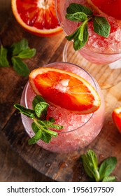 Homemade Italian Granita Dessert With Blood Orange, Elderflower, Rose Wine  In Serving Glasses On A Wooden Tray On A Wooden Table.