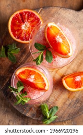 Homemade Italian Granita Dessert With Blood Orange, Elderflower, Rose Wine  In Serving Glasses On A Wooden Tray On A Wooden Table.