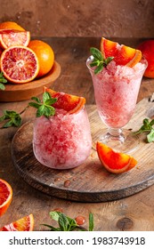 Homemade Italian Granita Dessert With Blood Orange, Elderflower, Rose Wine  In Serving Glasses On A Wooden Tray On A Wooden Table.