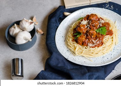 The Homemade Italian Pasta Or Spaghetti With Meatball , Cheese And Tomato Sauce Placed In A White Dish With On Dark Blue Tablecloth On The Table.
