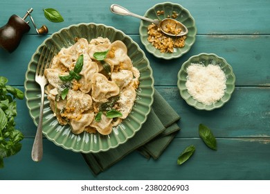 Homemade italian ravioli pasta in heart shape with beef meat, cheese sauce, caramelized onions, basil and saffron on old wooden blue background. Food cooking menu ingredients background. Top view. - Powered by Shutterstock