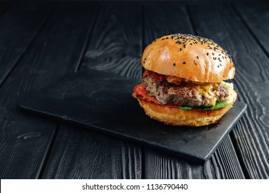 homemade  juicy burger on dark wooden board. Street food, fast food. - Powered by Shutterstock