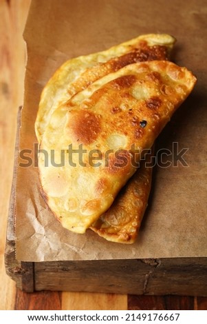 Homemade juicy golden deepfried turnovers chebureks on baking paper. Traditional Turkic-Mongolian dish. Street food
