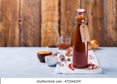 Homemade ketchup in bottle with label, ingredients on the table. Copy space.