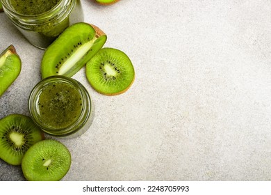 Homemade kiwi jam in a jar and kiwi slyces on concrete background with copy space. - Shutterstock ID 2248705993