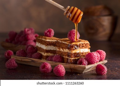 Homemade layered honey cake with cream and red raspberries.