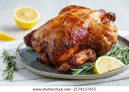 Homemade Lemon and Herb Rotisserie Chicken on a Plate, side view. Close-up.