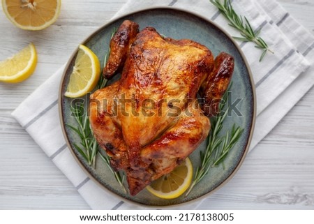 Homemade Lemon and Herb Rotisserie Chicken on a Plate, top view. Flat lay, overhead, from above. Close-up.