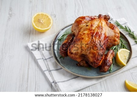 Homemade Lemon and Herb Rotisserie Chicken on a Plate, low angle view. Copy space.