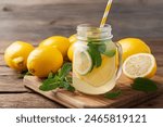 Homemade lemonade with lemon and mint in mason jar on wooden table. Refreshing summer drink. Drink making ingredients for lemonade.