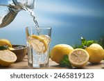 Homemade lemonade with lemon and mint in mason jar on wooden table. Refreshing summer drink. Drink making ingredients for lemonade.