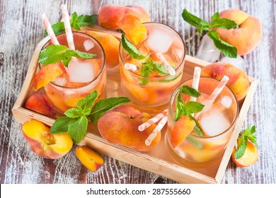 Homemade lemonade with ripe flat saturn-shaped peaches and fresh mint