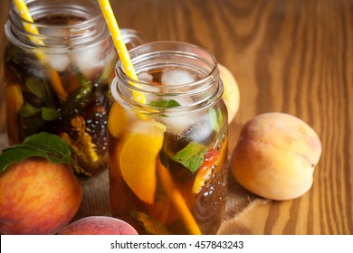 Homemade lemonade of ripe peaches and cold fresh mint. A jar of peach tea. Refreshing water.