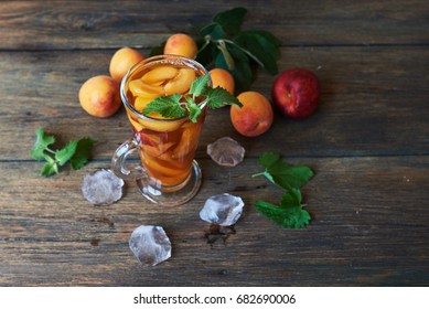 Homemade lemonade of ripe peaches and fresh mint. A glass of peach tea. Refreshing water.