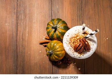 Homemade Loaded Pumpkin Spice Milk Shake With Ice Cream And Tart Crumble, In Single Glass With Little Pumpkins Decor, Pecan Nuts And Spices, Healthy Fall Seasonal Breakfast Drink