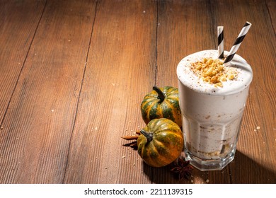 Homemade Loaded Pumpkin Spice Milk Shake With Ice Cream And Tart Crumble, In Single Glass With Little Pumpkins Decor, Pecan Nuts And Spices, Healthy Fall Seasonal Breakfast Drink