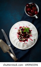 Homemade Meringue Cake Pavlova With Whipped Cream, Fresh Cherry And  Sauce  On Dark Concrete Texture Background.Selective Focus. Top View, Space