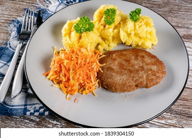 Homemade Minced Meat Cutlet Served With Mashed Potatoes And Carrot Salad.