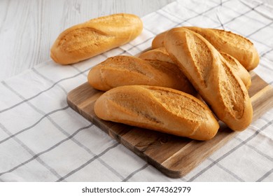Homemade Mini baguettes on a wooden board, side view. - Powered by Shutterstock