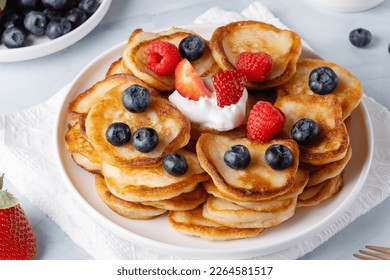 Homemade mini pancakes with blueberries, strawberries and raspberries