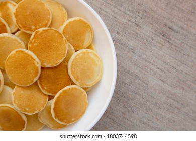 Homemade Mini Pancakes Cereal In A White Bowl, Top View. Flat Lay, Overhead, From Above. Space For Text.