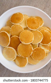 Homemade Mini Pancakes Cereal In A White Bowl, Overhead View. Flat Lay, Top View, From Above. 