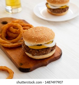 Homemade Mississippi Slug Burgers With Onion Rings And Glass Of Cold Beer On A White Wooden Surface, Side View. Close-up.