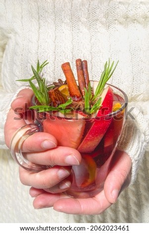 Homemade mulled wine cocktail. Various glass mugs with classic winter hot spicy mulled wine, in womans hands background flatlay top view copy space