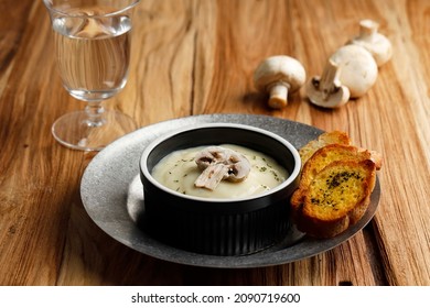 Homemade Mushroom Creamy Soup With Crispy Garlic Bread Baguette, Serve On Black Ceramic Bowl Or Ramequin Above Rustic Table