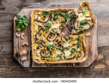 Homemade mushrooms pie on a wooden background.