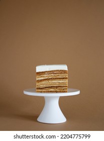 homemade natural honey cake on brown background and cake stand