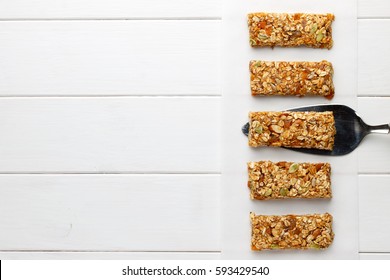 Homemade no bake granola bars on white wooden background. Top view, copy space.