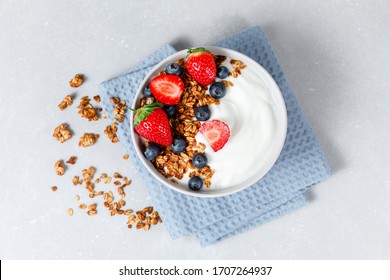 Homemade oatmeal granola smoothie bowl with berries on ligth grey background. Healthy breakfast concept. Organic oat, almond and sunflower seeds. Top view. - Powered by Shutterstock