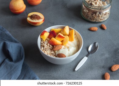 Homemade oatmeal granola with yogurt and peaches in bowl for healthy breakfast. Cereal and fruit breakfast bowl with yogurt.