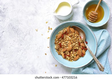 Homemade organic granola with almond and goji berries  on grey concrete texture background. - Powered by Shutterstock