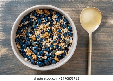 Homemade organic green buckwheat with blueberries, walnuts, pumpkin seeds and honey in a ceramic bowl on a wooden background. Healthy vegetarian breakfast, close up, top view - Powered by Shutterstock