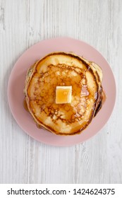 Homemade Pancakes With Butter And Maple Syrup On A Pink Plate Over White Wooden Background, Overhead View. Top View, Flat Lay, From Above. 