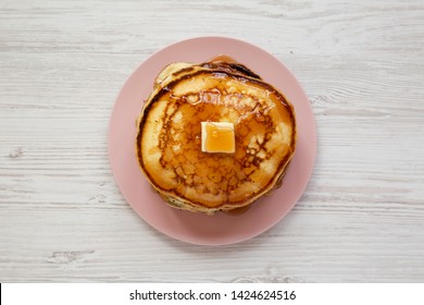 Homemade Pancakes With Butter And Maple Syrup On A Pink Plate On A White Wooden Background, Overhead View. Top View, Flat Lay, From Above. Close-up.