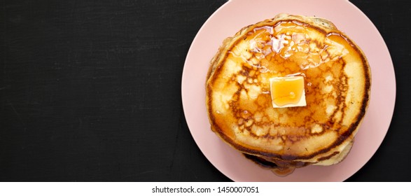 Homemade Pancakes With Butter And Maple Syrup On A Pink Plate On A Black Background, Top View. Flat Lay, Top View, From Above. Space For Text.