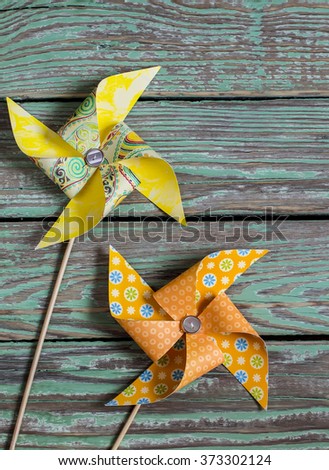 Homemade paper pinwheel on a wooden rustic background . Vintage and rustic style      