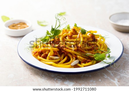 Homemade pasta with red pesto and almond