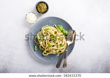Homemade pasta, spaghetti, linguine with green pesto and basil. Italian healthy food concept with copy space, top view.