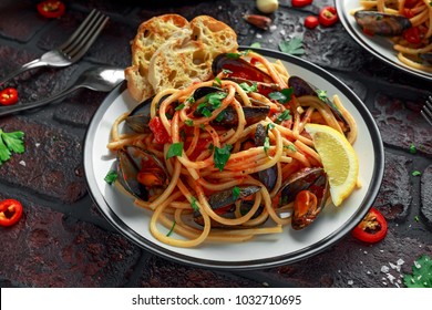 Homemade Pasta Spaghetti with mussels, tomato sauce, chilli and parsley on rustic background. sea food meal - Shutterstock ID 1032710695