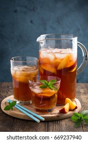 Homemade peach and lemon ice tea with mint on rustic background