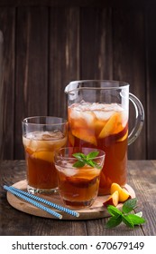 Homemade peach and lemon ice tea with mint on rustic background