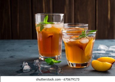 Homemade peach and lemon ice tea with mint on rustic background