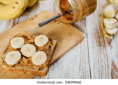 Homemade peanut butter and banana sandwich on wooden background - Shutterstock ID 508398460